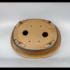 Underside of ochre oval pot showing two large openings and corner feet