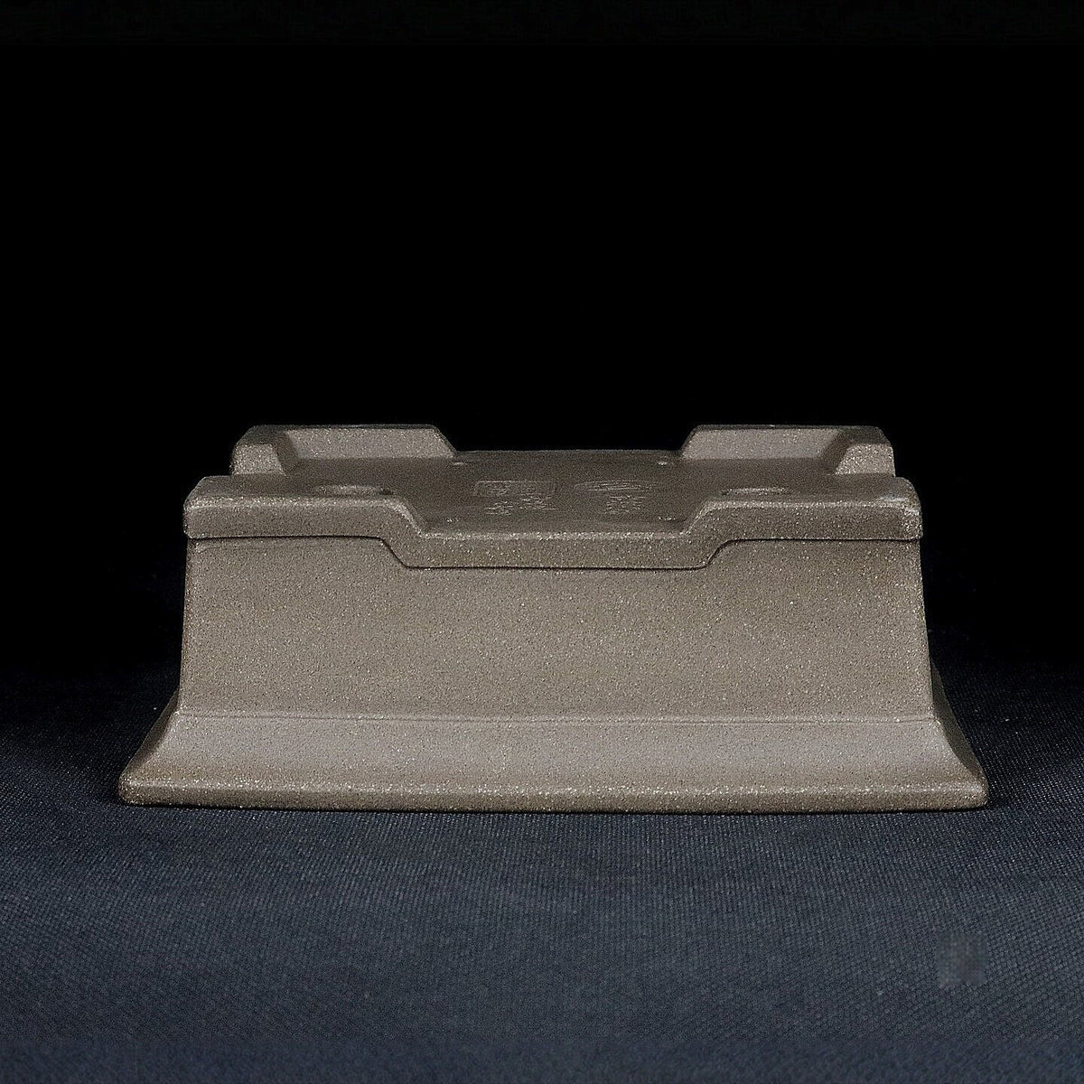 Upside-down gray rectangular pot showing raised feet and base profile