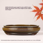 Brown-gold glazed oval pot with decorative feet and measurement labels