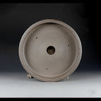 Interior of the taupe round pot with central drainage opening and three smaller holes