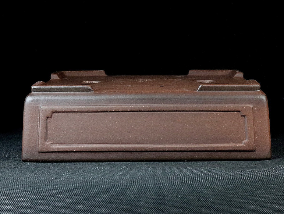 Low underside angle showing the brown pot's recessed panel and feet