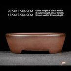 Brown oval pot with low cutout feet and measurement annotations