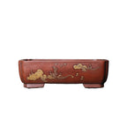Isolated red-brown pot with gold-colored landscape motif