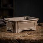 Tan rectangular bonsai pot with recessed side panel and broad feet