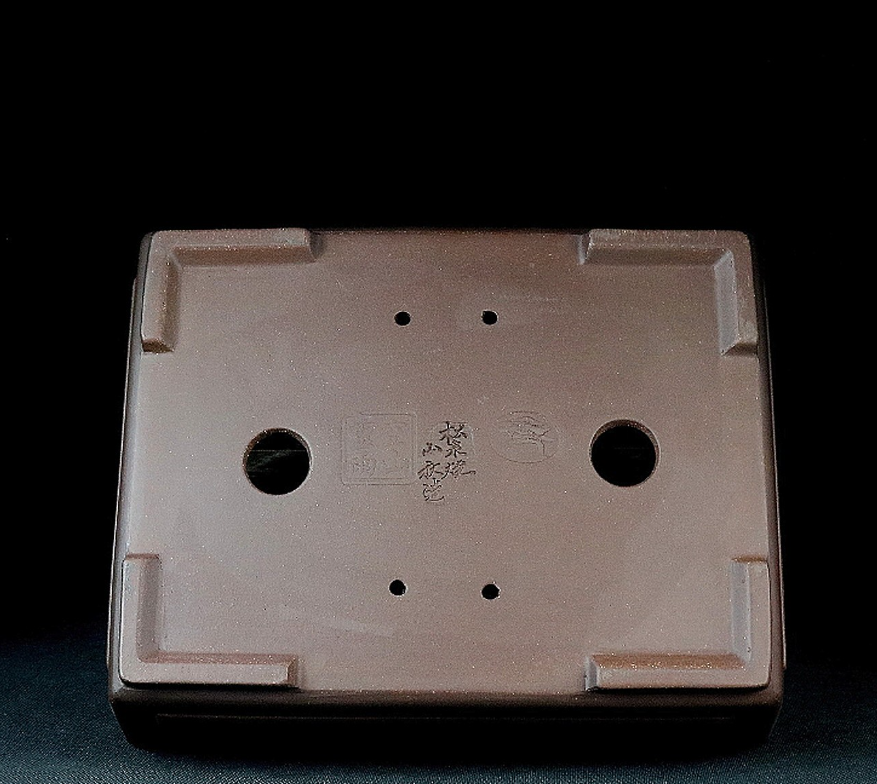 Underside of the rectangular pot with two drainage holes and impressed marks