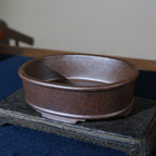 Angled view of mottled brown oval pot showing interior
