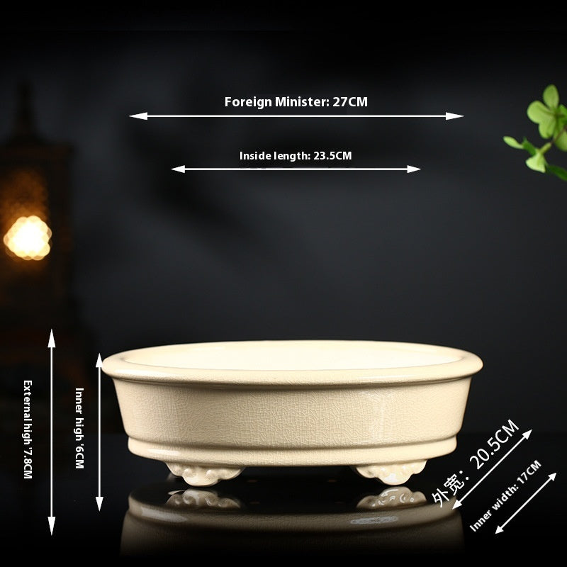 Ivory oval bonsai pot with decorative feet and exterior and interior measurement arrows