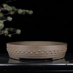 Taupe round drum pot with raised studs and low feet