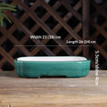 Green oval bonsai pot with a pale interior, low feet and measurement labels