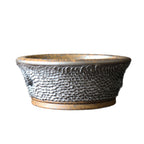 Side view of round bonsai pot with raised scale texture and amber base