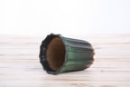 The dark green tall fluted bonsai pot lying on its side to show the opening and fluted walls