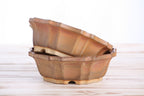 Two matching warm tan-brown pots stacked at an angle to show their profiles