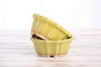 Two matching yellow pots stacked at an angle to show their profiles