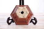 Underside of the rust-red hexagonal bonsai pot showing drainage openings, feet and impressed maker's marks