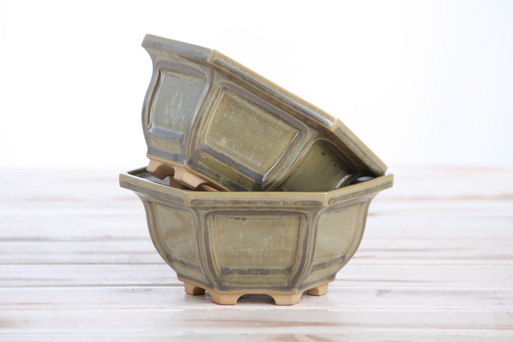 Two matching pale olive-gray pots stacked at an angle to show their profiles