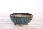 Angled view of the blue-green round fluted bonsai pot showing its rim and side profile