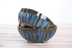 Two matching blue-green pots stacked at an angle to show their profiles