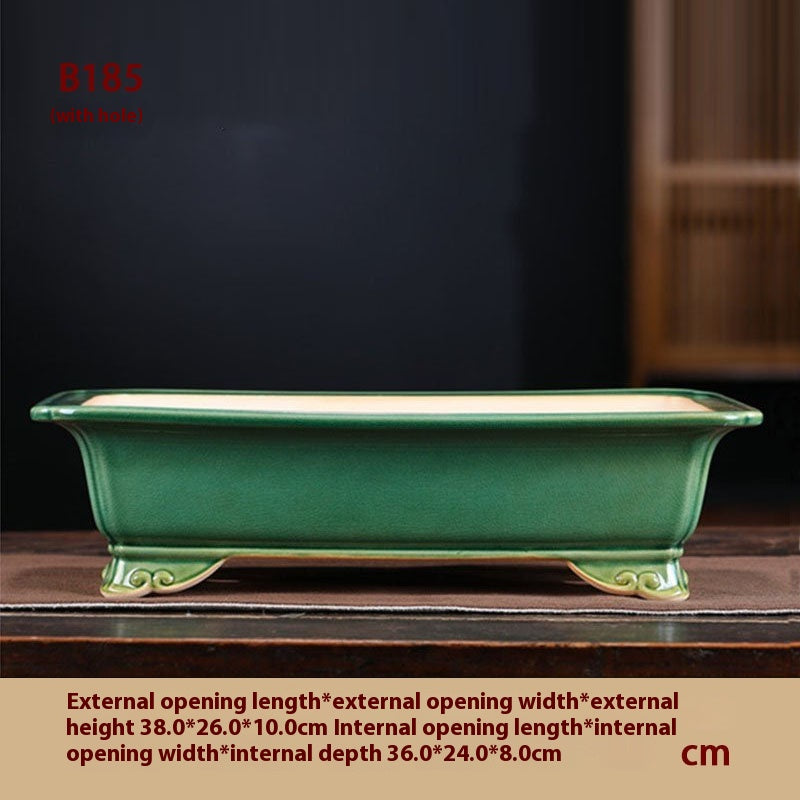 Green rectangular bonsai pot with a pale interior and curled corner feet, with measurement labels