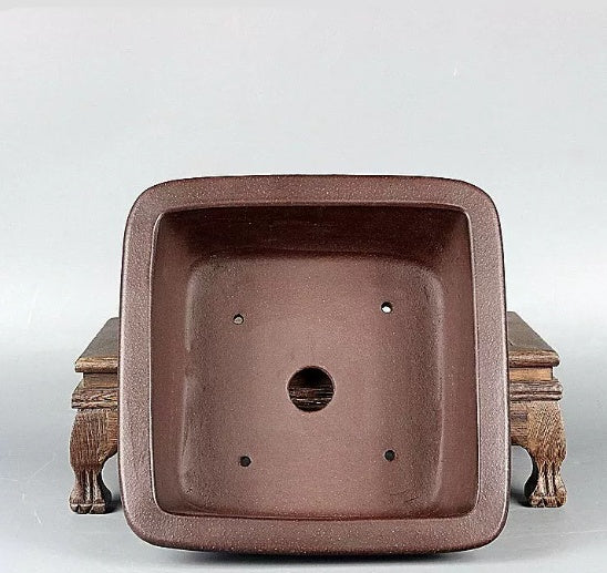 Top view of brown square pot showing central opening and four small holes
