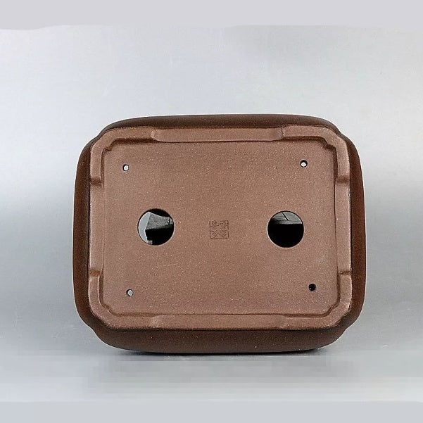 Underside of the brown rectangular pot with two drainage holes and four smaller openings