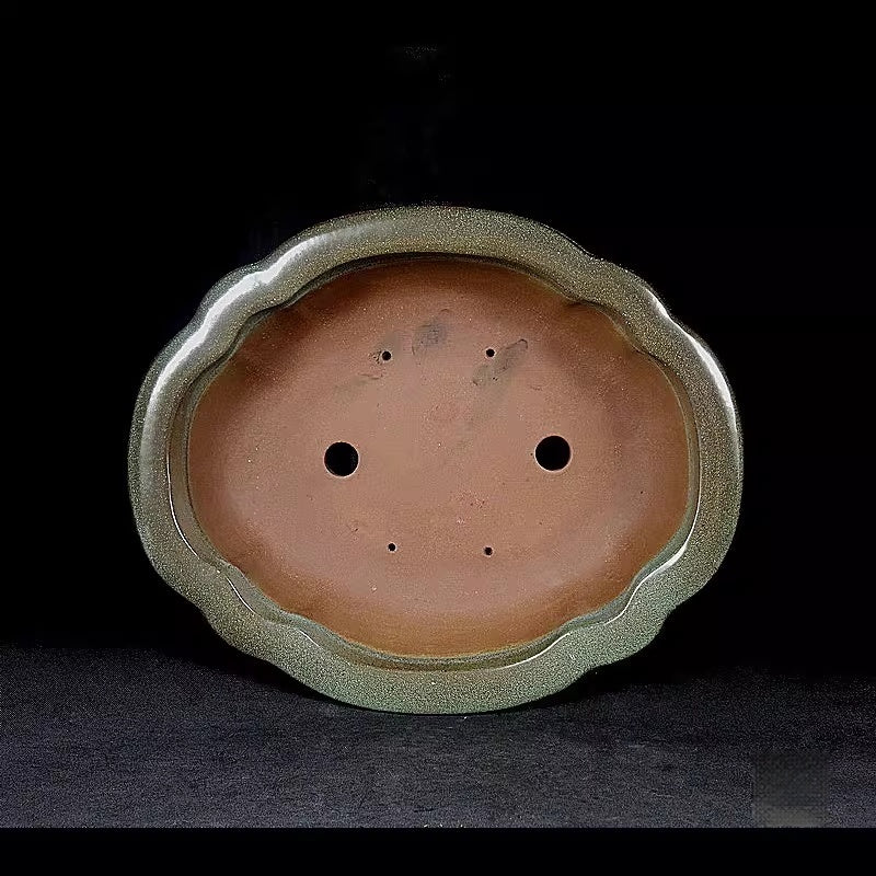 Interior drainage holes and scalloped outline of mokko pot