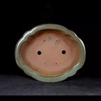 Interior drainage holes and scalloped outline of mokko pot