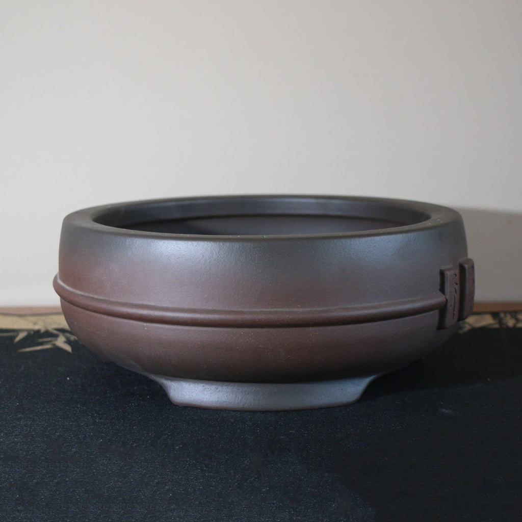 Rounded body and raised feet of dark-brown bonsai pot