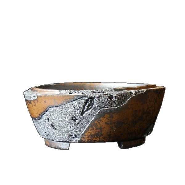 Isolated round pot with amber surface and charcoal texture
