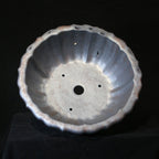 Top view of dark lotus-shaped bonsai pot showing fluted interior, central opening and smaller holes