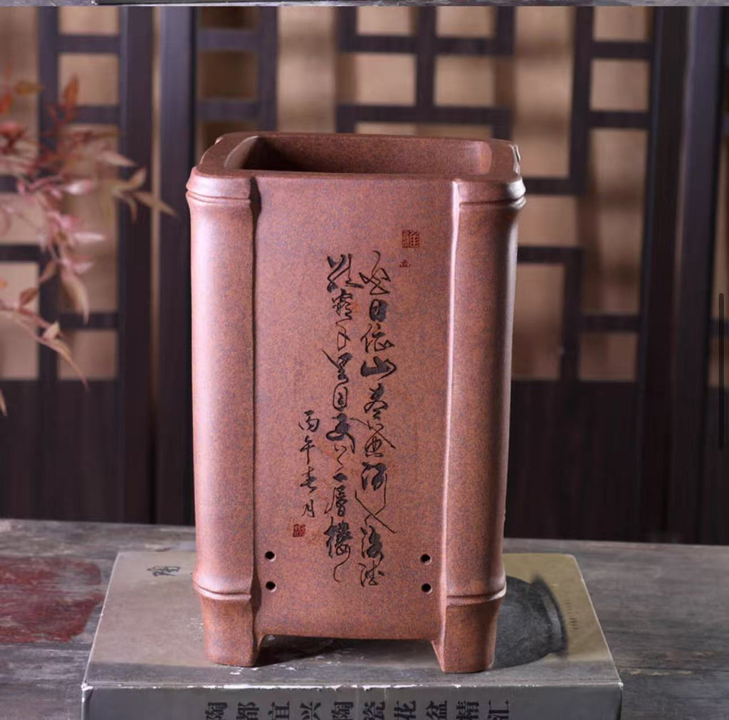 Calligraphy on a reddish-brown square pot with bamboo-shaped corner columns