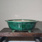 Emerald-green glazed lobed pot with flared rim and angular feet