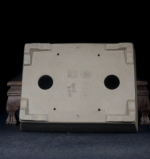 Underside of the taupe pot showing corner feet, drainage holes and impressed marks