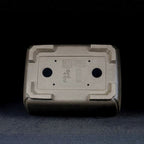 Underside of gray-brown rectangular pot showing two large openings and stamped marks