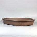 Shallow brown oval bonsai pot with broad rim and low feet