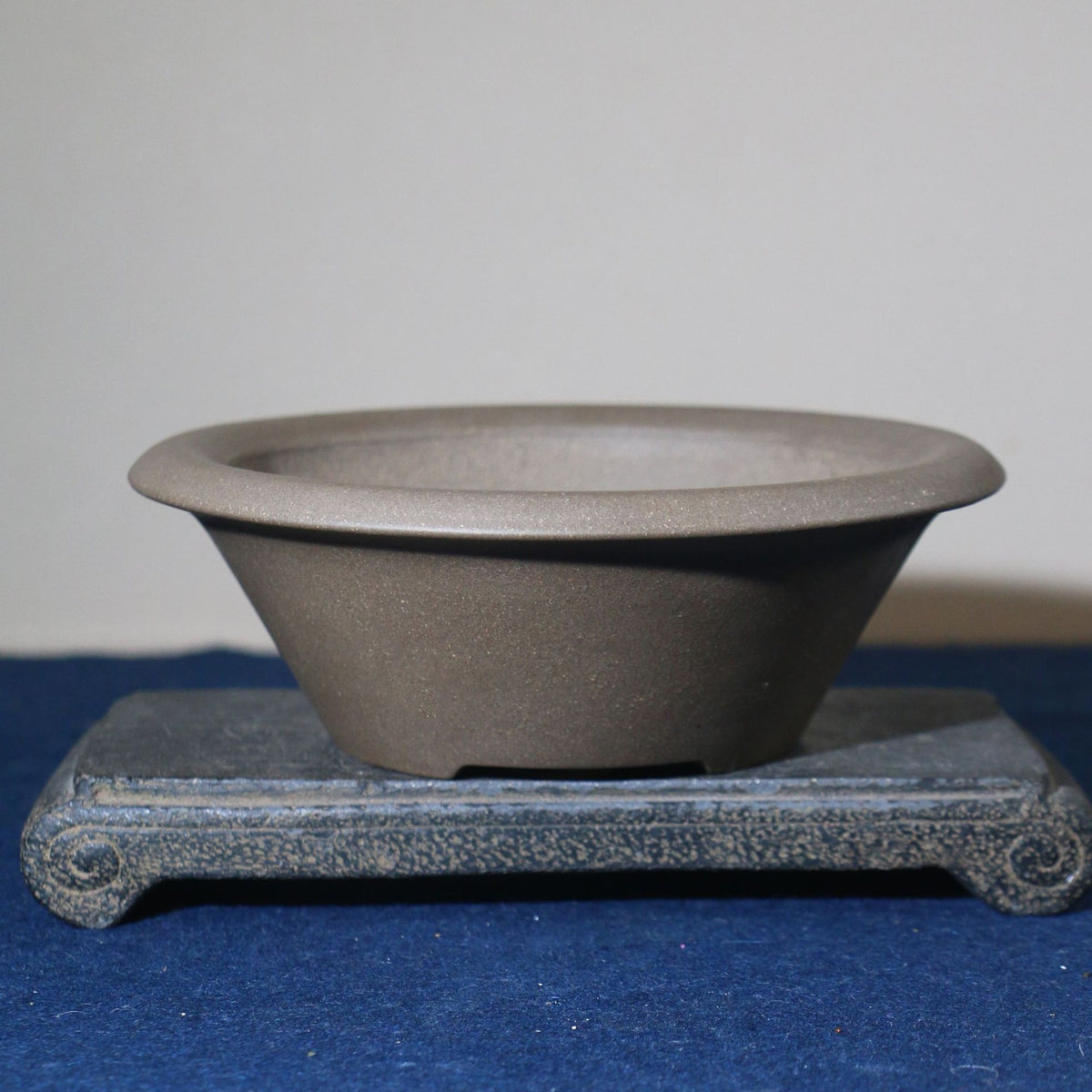 Angled gray conical pot showing open rim and tapered wall