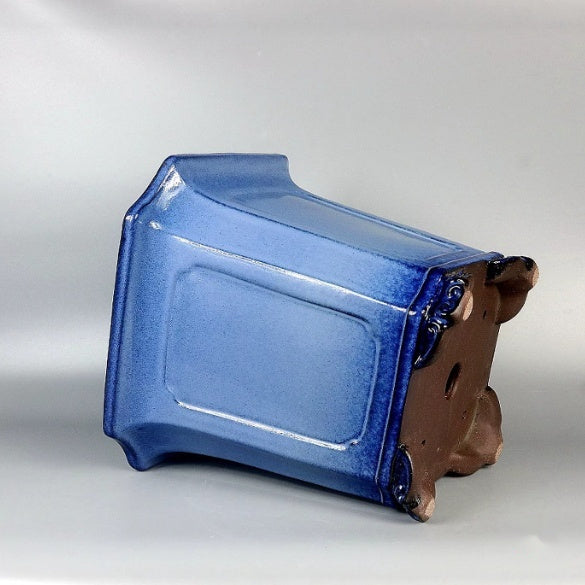 Blue-glazed tall square bonsai pot lying on its side showing paneled wall