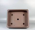 Interior of the brown rectangular pot showing five large drainage openings
