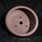 Interior of the reddish-brown round pot with central drainage hole