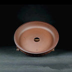 Interior view of a reddish-brown round pot with central drainage opening