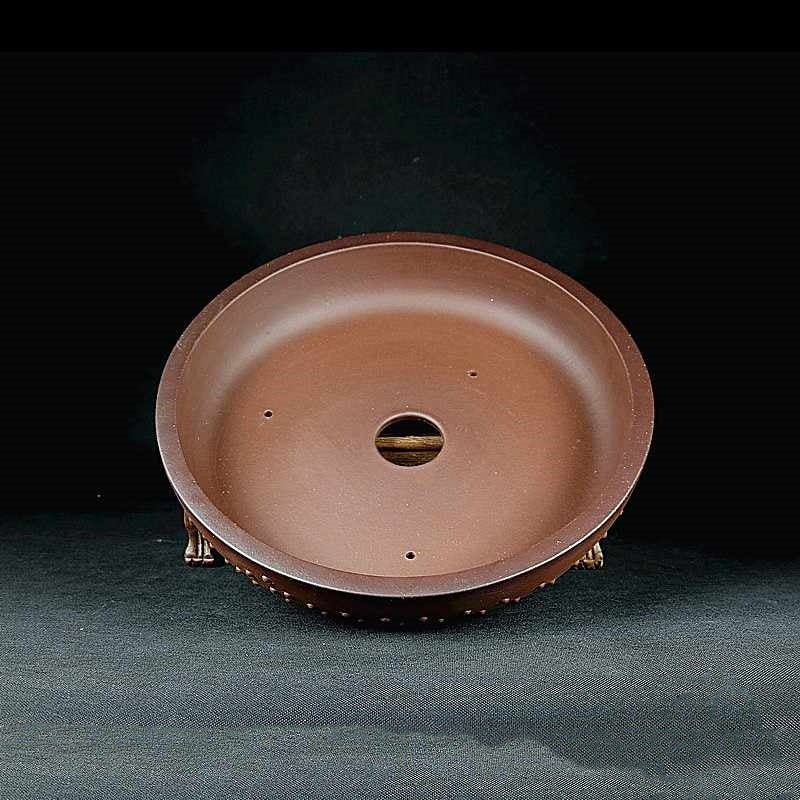 Interior view of a reddish-brown round pot with central drainage opening