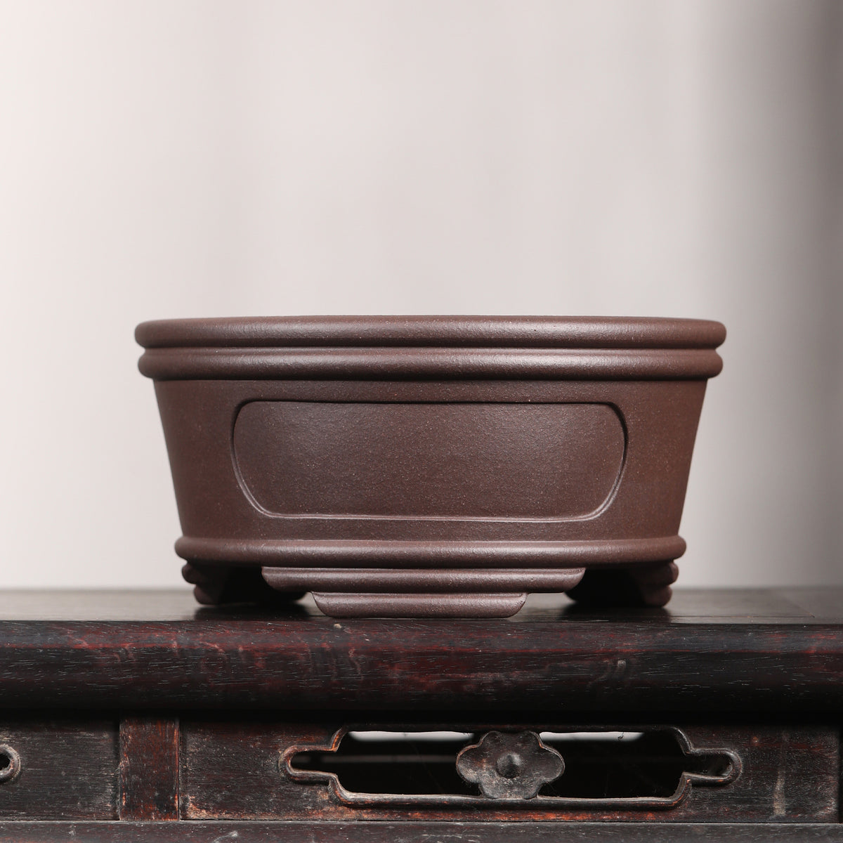 Front profile of brown round pot on a wooden stand