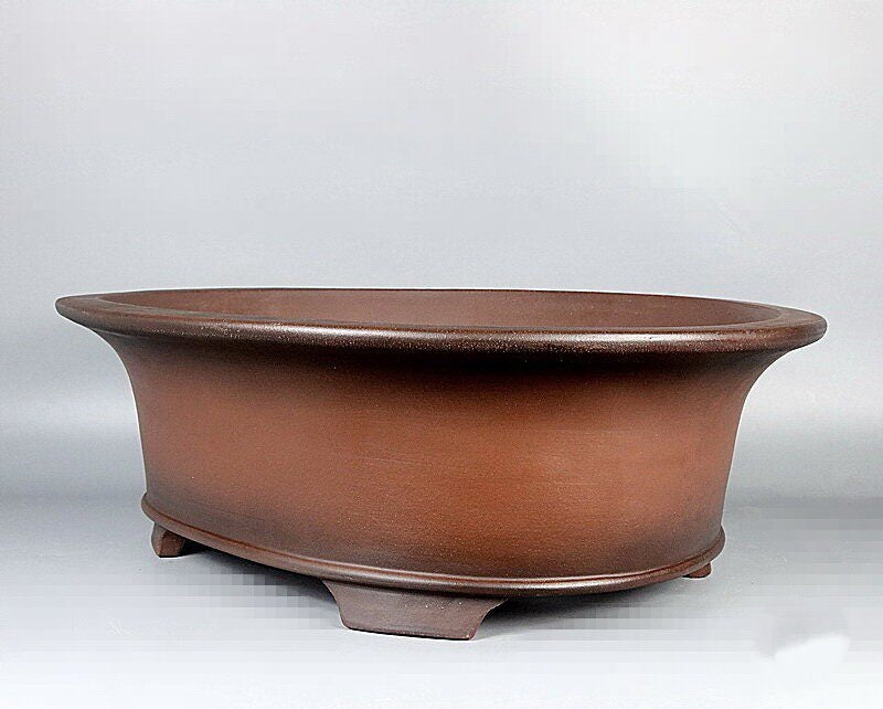 Angled brown oval pot showing flared rim and feet