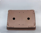 Underside of brown rectangular pot showing openings and corner feet