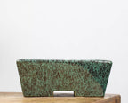 Front profile of green mottled rectangular pot on a wooden block