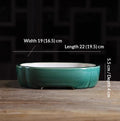 Deep green oval bonsai pot with a pale interior and low feet, with measurement labels