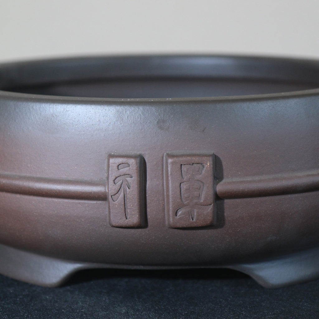 Decorative plaques and horizontal band on round clay pot