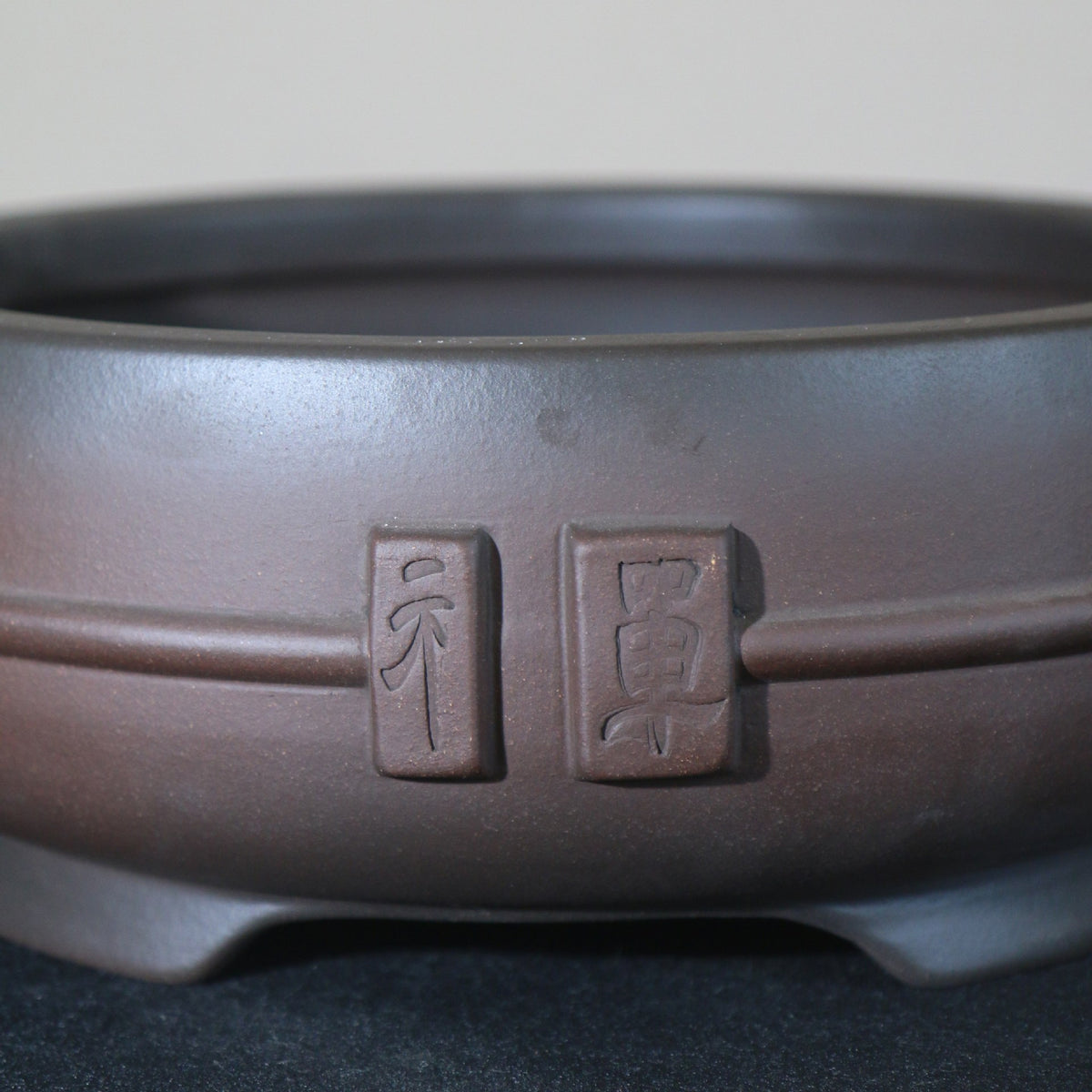 Decorative plaques and horizontal band on round clay pot