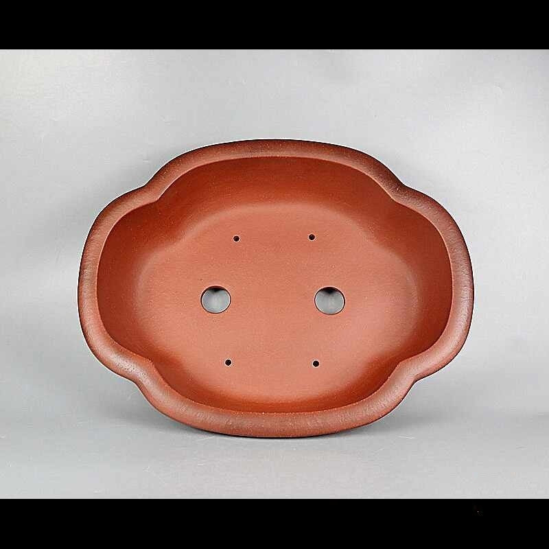 Top view of red-orange lobed pot showing two large openings and small holes