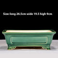 Green rectangular bonsai pot with recessed side panels and curled feet, with dimensions above