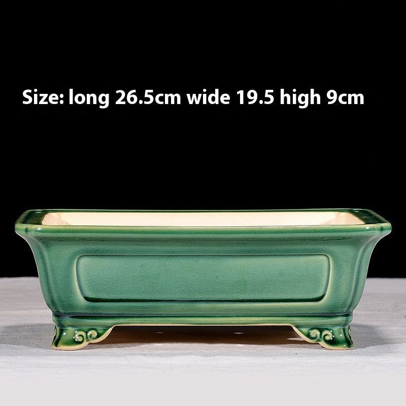 Green rectangular bonsai pot with recessed side panels and curled feet, with dimensions above